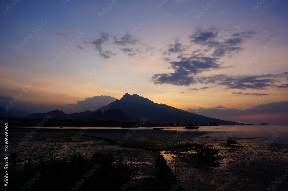  sunset and sunrise on the beach with a mountain backdrop