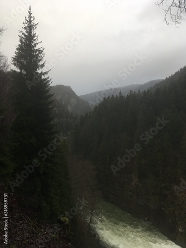 Canvas Print water power - heavy flood on river in winter provoking mist