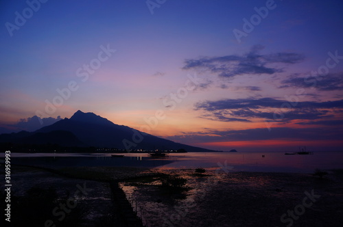  sunset and sunrise on the beach with a mountain backdrop