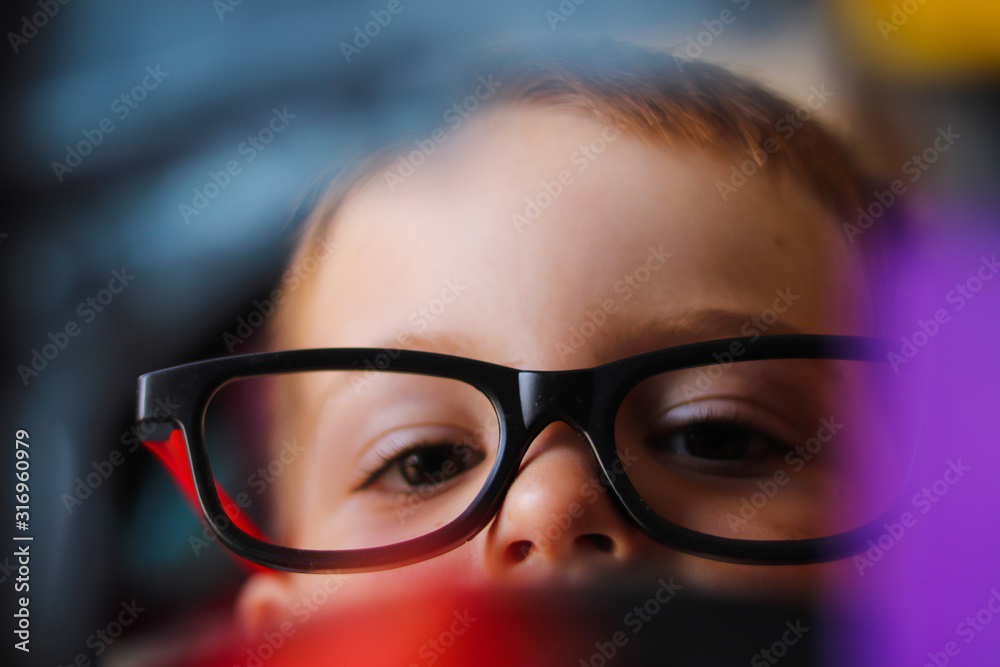 Fototapeta premium Young Boy playing with glasses on