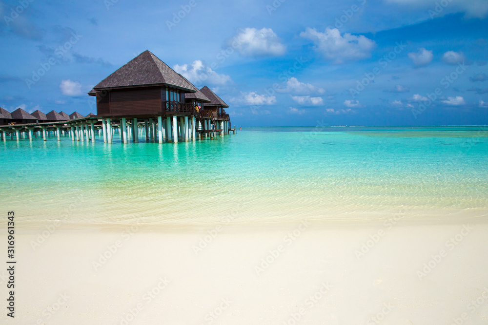 tropical Maldives island with beach. Sea with water bungalows