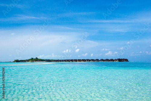 Beautiful tropical Maldives island with beach. Sea with water bungalows