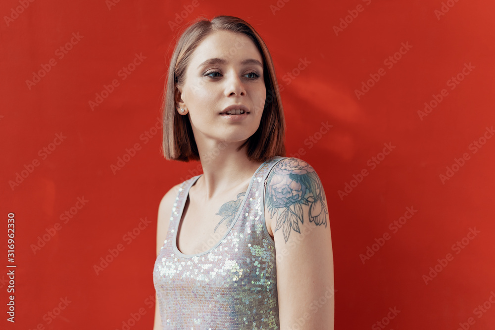 Cheerful young girl posing in front of a red wall