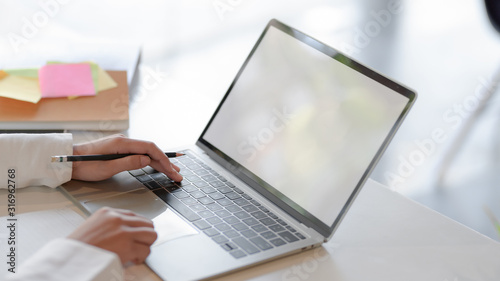 Cropped shot of businesswoman typing on blank screen laptop