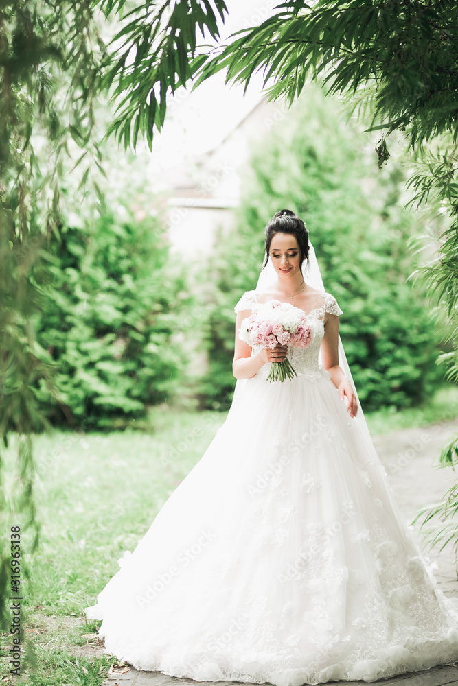 Portrait of stunning bride with long hair posing with great bouquet