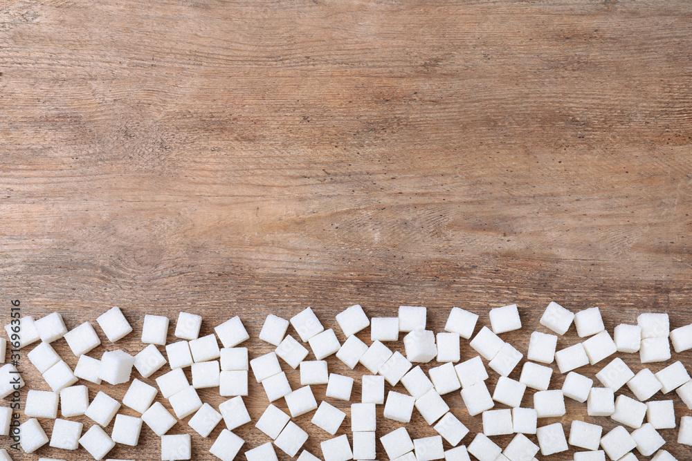 Refined sugar on wooden table, flat lay. Space for text Refined sugar on wooden table, flat lay. Space for text