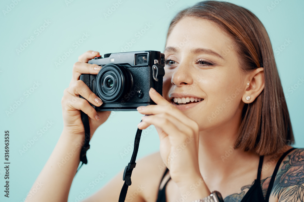 Young girl photographer taking photos on blue background Young girl photographer taking photos on blue background