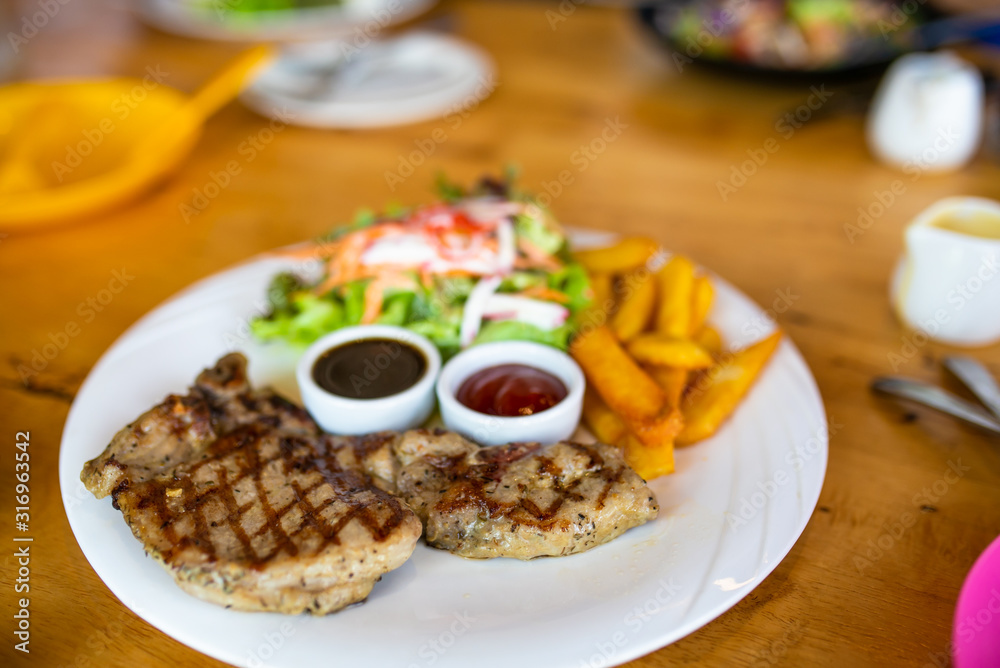 Grilled meat, Porkchops steak with pepper sauce and salad.