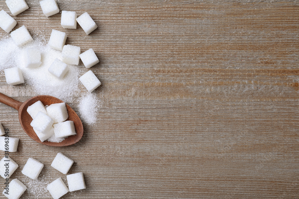 Refined sugar on wooden table, flat lay. Space for text Refined sugar on wooden table, flat lay. Space for text