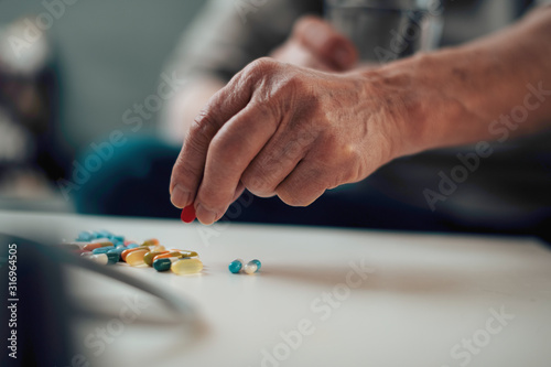 Close up of old man taking pills. Senior man drinking medicine. 