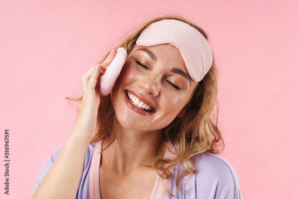 Image of caucasian cheerful woman smiling while using cosmetic sponge Image of caucasian cheerful woman smiling while using cosmetic sponge