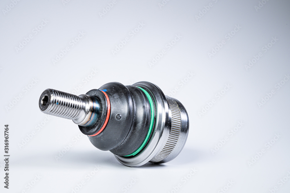 New spare parts spherical ball joints of a suspension bracket of a car on a gray background New spare parts spherical ball joints of a suspension bracket of a car on a gray background