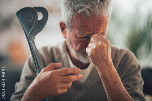 Foto Old man with crutches. Senior man having pain.
