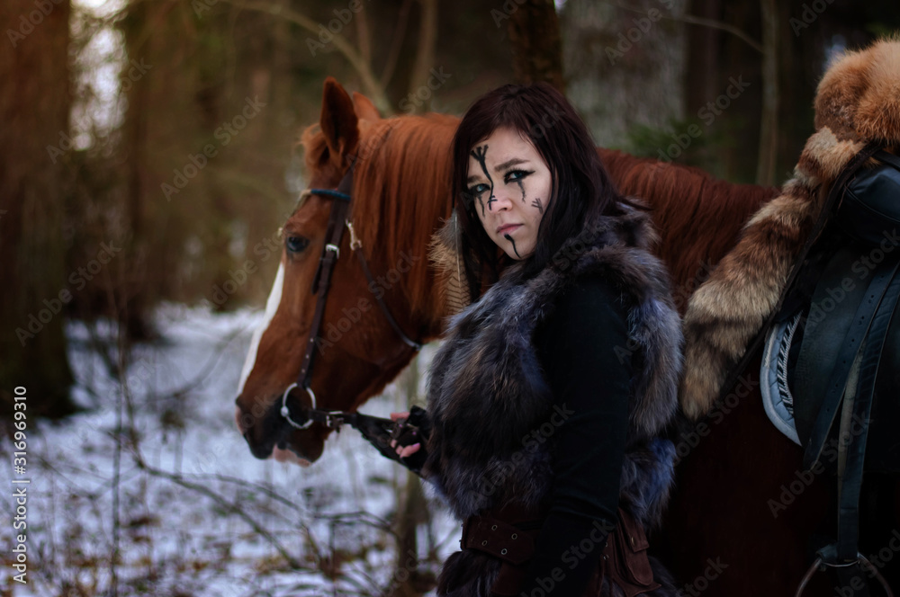 Photo & Art Print a Viking girl next to a red horse painted in 
