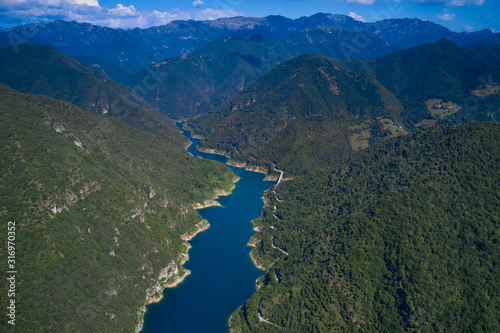 Aerial view, Lake Valvestino, Italy. Beautiful lake between the mountains. Cumulus clouds, blue sky