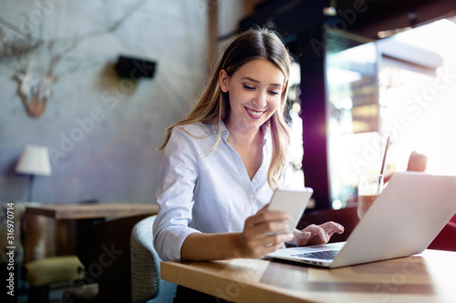 Portrait of cheerful coworker business woman working on laptop