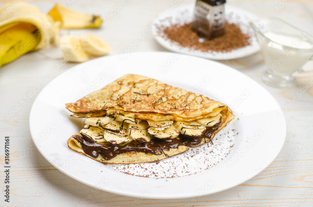 Homemade thin pancakes made with oat flour, banana, chocolate and nuts. Healthy food, proper nutrition breakfast