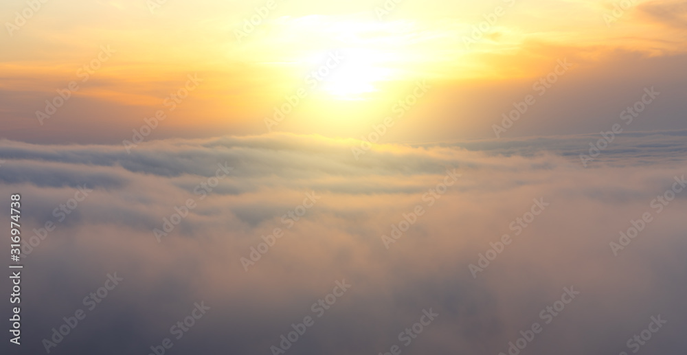 Beautiful aerial view from above clouds with sunset. Airplane view.