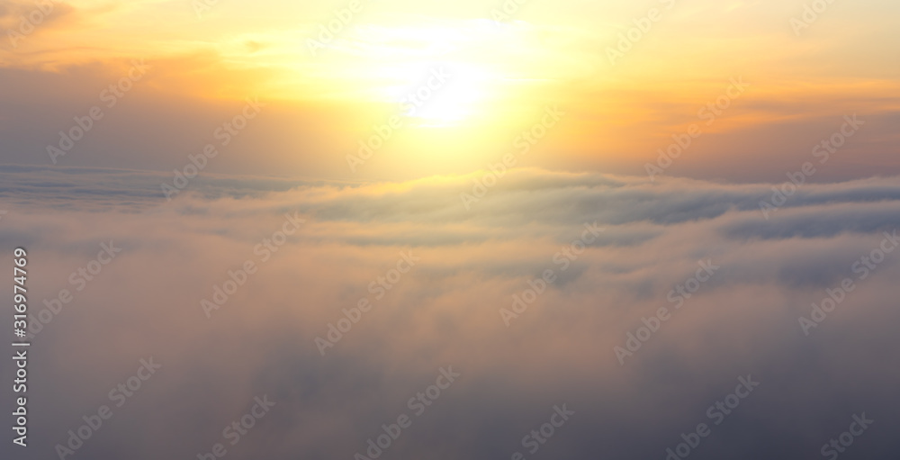 Beautiful aerial view from above clouds with sunset. Airplane view.