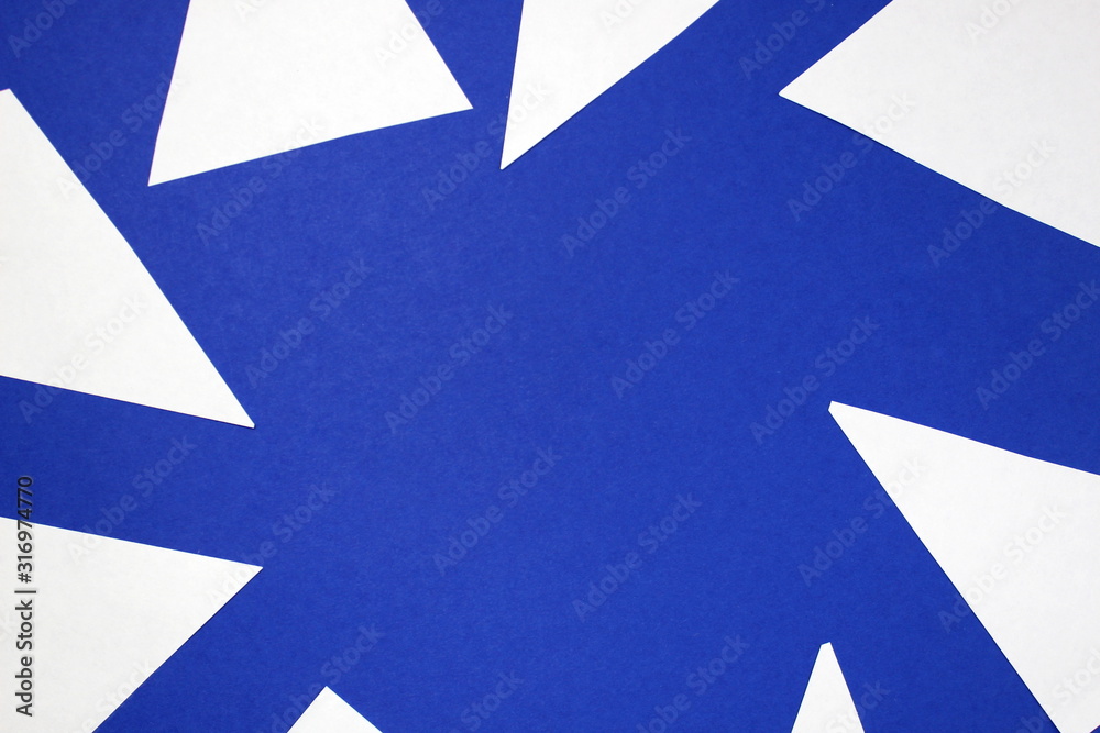 Small white paper sheets with sharp corners lie on a blue background Small white paper sheets with sharp corners lie on a blue background