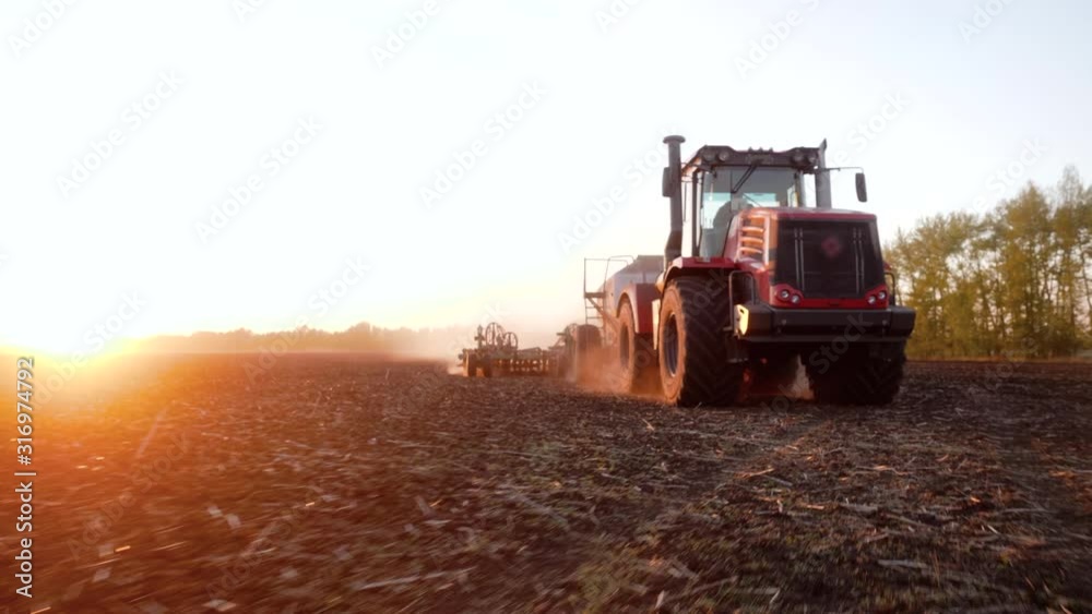 Rural seasonal works on farm land by industrial farming machinery or tractor on nature field at sunset. Agricultural cultivation for production organic food. Concept of farmland, agriculture equipment