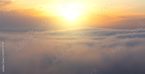 Beautiful aerial view from above clouds with sunset. Airplane view.