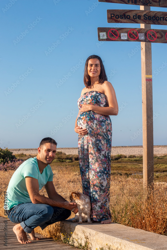 Pregnant happy couple with small dog