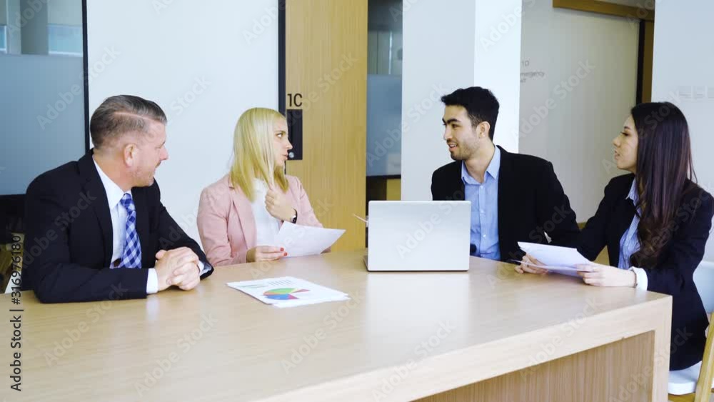 Young businessman discussing with his partners during a business meeting while sitting in the office room. Shot in 4k resolution Young businessman discussing with his partners during a business meeting while sitting in the office room. Shot in 4k resolution