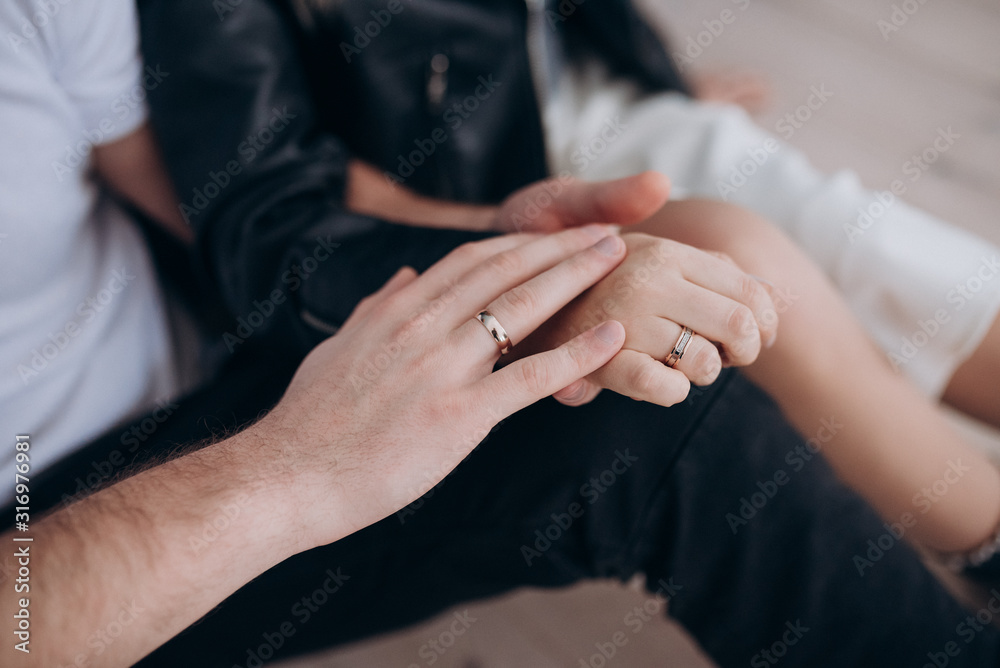a man and a woman with wedding rings hold each other's hands a man and a woman with wedding rings hold each other's hands