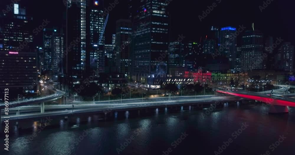 Fast-moving revealing AERIAL hyperlapse of Brisbane city CBD at night.