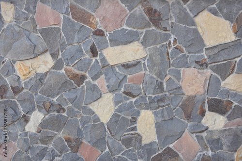 Wall texture of natural chipped stone with cement joints. Decorative stone background. Cobblestone pavement close up. photo