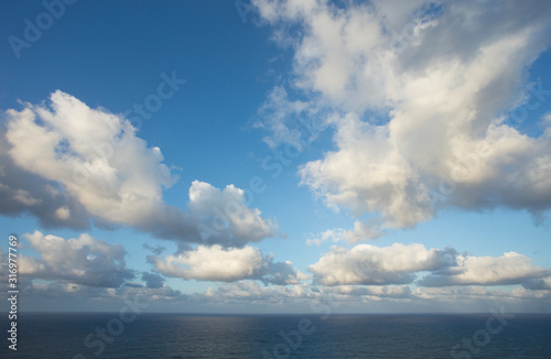 meadow with green grass and clouds over the sea