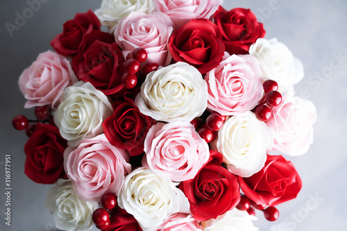 Flowers in bloom  Bouquet of red and white roses on a gray background.