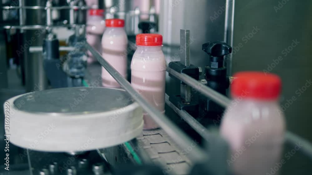Plastic bottles with yogurt on a factory line. Plastic bottles with yogurt on a factory line.