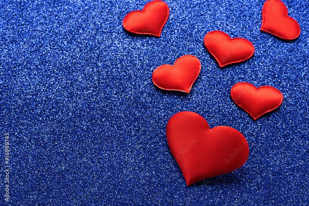 Obraz premium Red hearts symbol of love on a shiny blue background. Valentines day concept. Horizontal frame copy space.