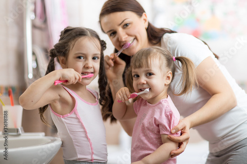 happy family mum and kids brushing their teeth
