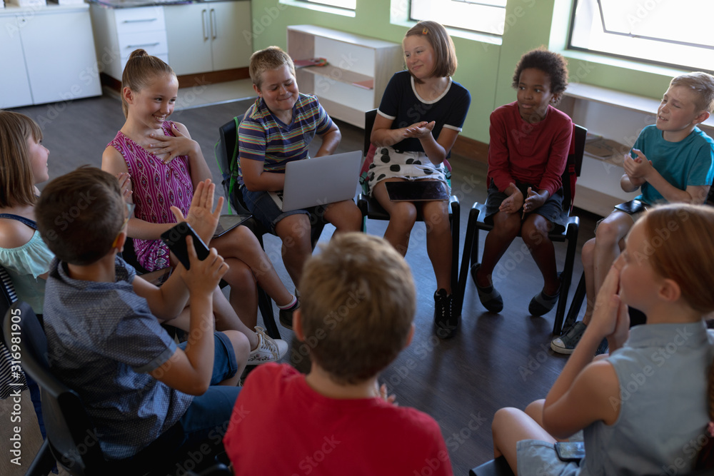 Obraz premium Group of elementary school kids sitting in a circle