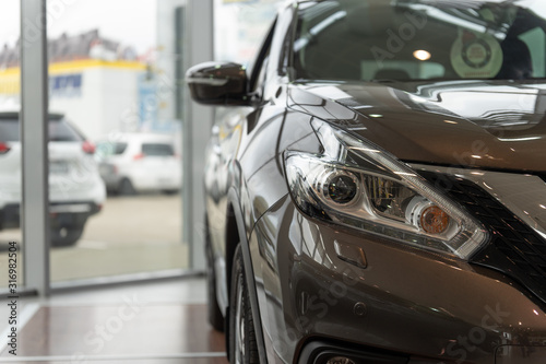 Front view of the vehicle for sale in the showroom. Car dealership © Aleksandr