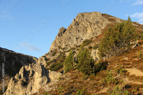 Mountains, sun and blue sky on summer day. Beautiful mountain background