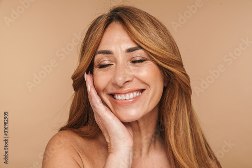 Portrait of shirtless adult woman touching her face and smiling