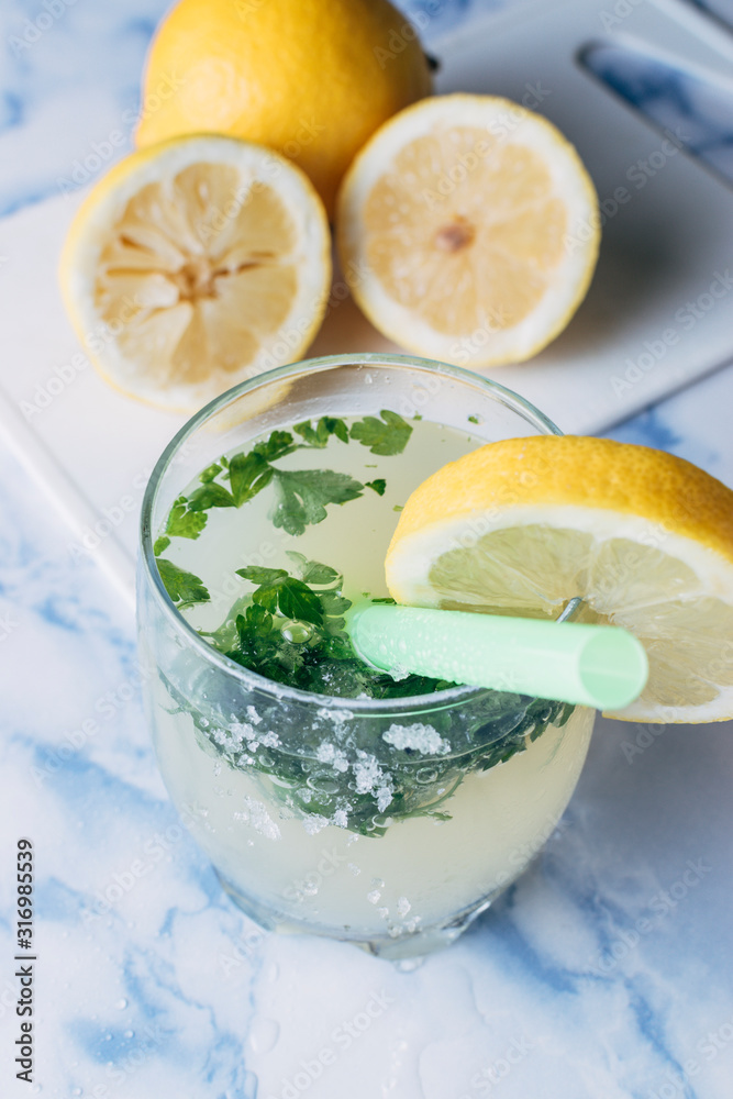 Close-up of a glass of lemonade with aromatic herbs with the lemons cut from the bottom Close-up of a glass of lemonade with aromatic herbs with the lemons cut from the bottom