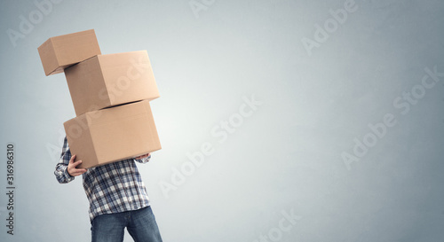 Man holding heavy cardboard boxes relocation, moving house or courier delivery photo