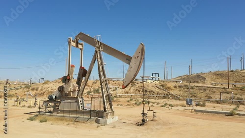Oil Pump jack. Oil industry equipment. Morning, blue sky. California. USA country