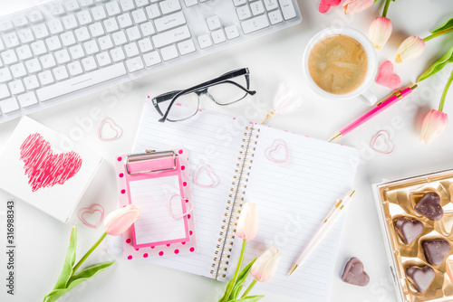 Modern office desk workspace with laptop keyboard, notebook and stationery. Springtime and valentine day pastel workspace background. Flat lay lifestyle with copy space
