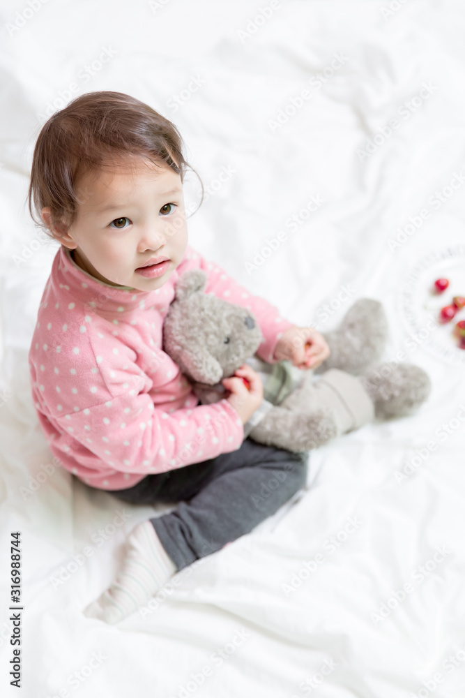 Enfant mix 2 ans franco chinois assis avec nounours