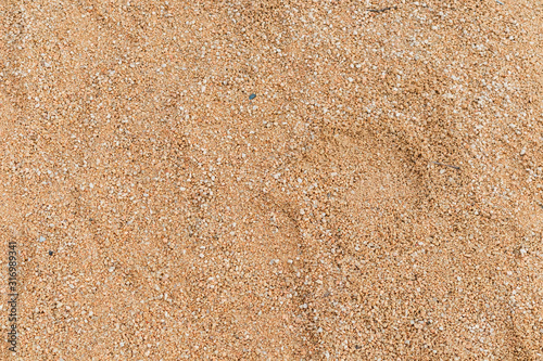 arena de playa de un parque infantil. marron amarillo. piedrecitas. textura.