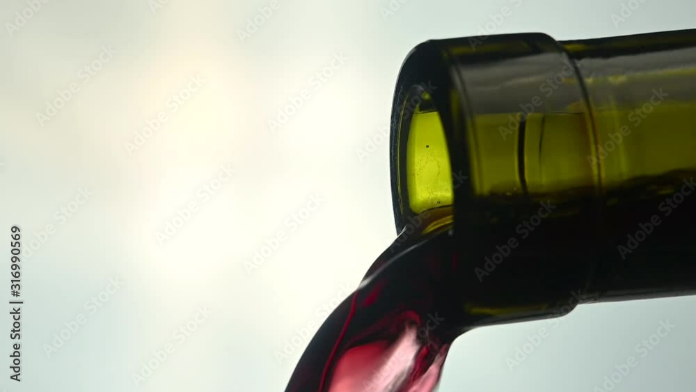 red wine pouring from a bottle of wine
