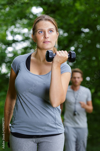 woman doing lunges with dumbbells in the forest photo