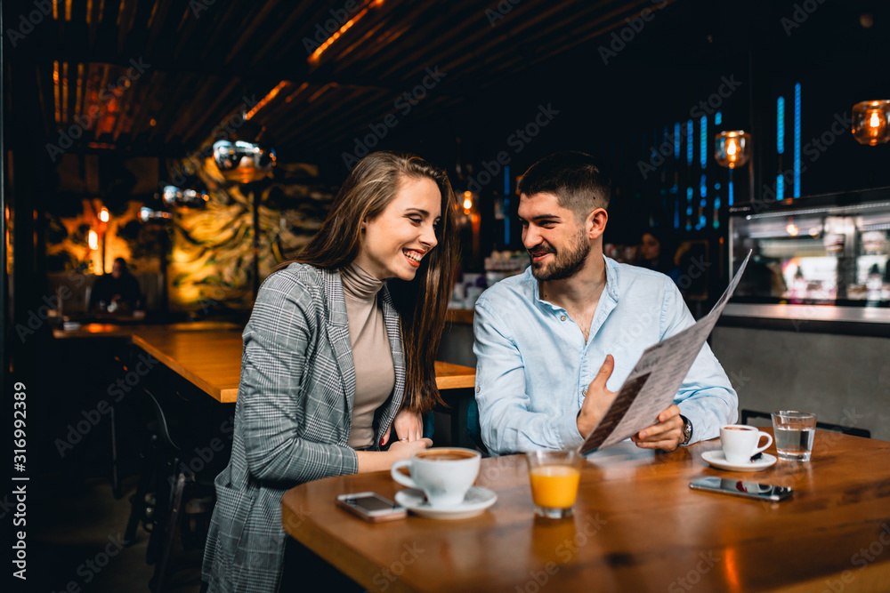 couple friends ordering food in restaurant