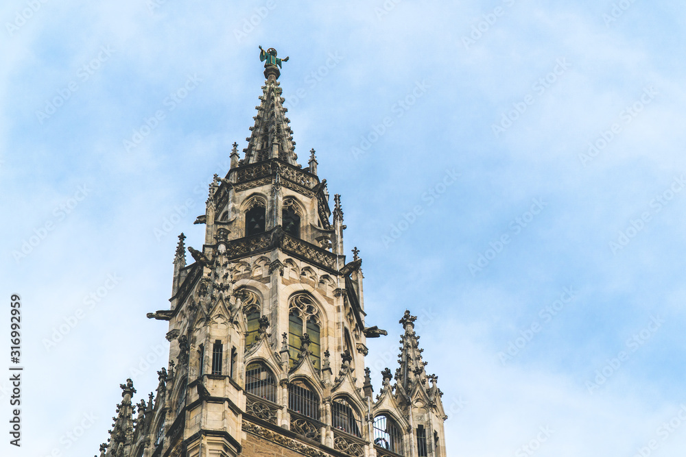 The New Town Hall, Neues Rathaus on Marienplatz main square, city government building with a tower clock. Gothic style. Photographed from below. Close up shot, texture